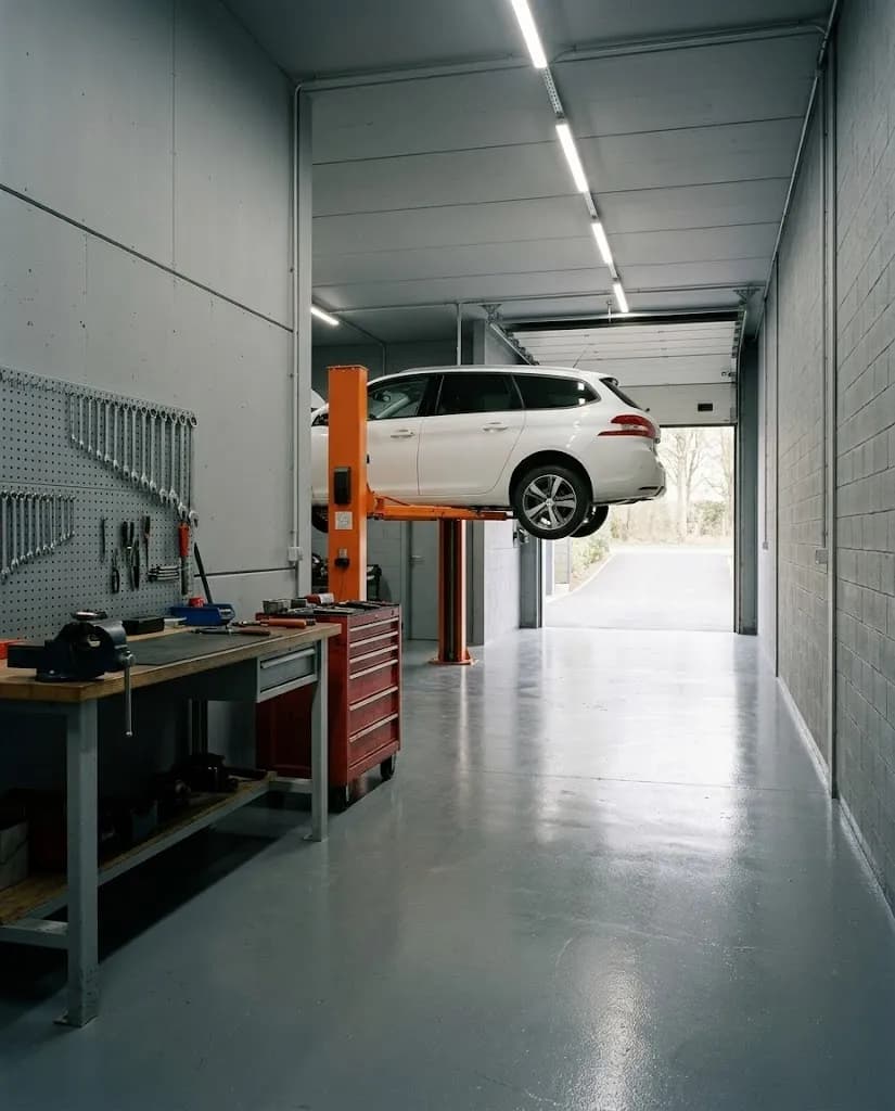 Interior da oficina Momeself com um carro no elevador e ferramentas na bancada